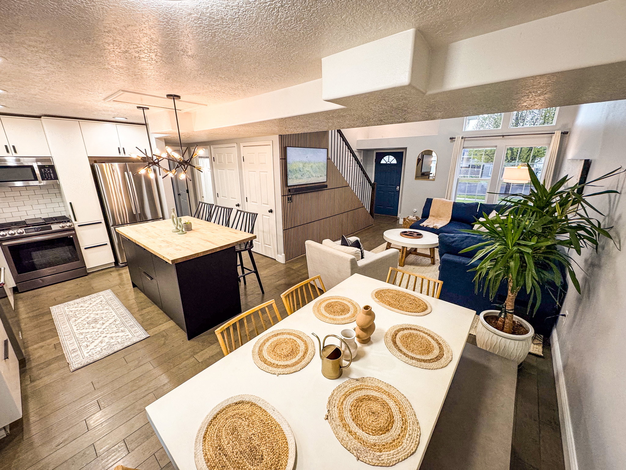 Dining space featuring dark wood-style flooring, a textured ceiling, and suspended lighting