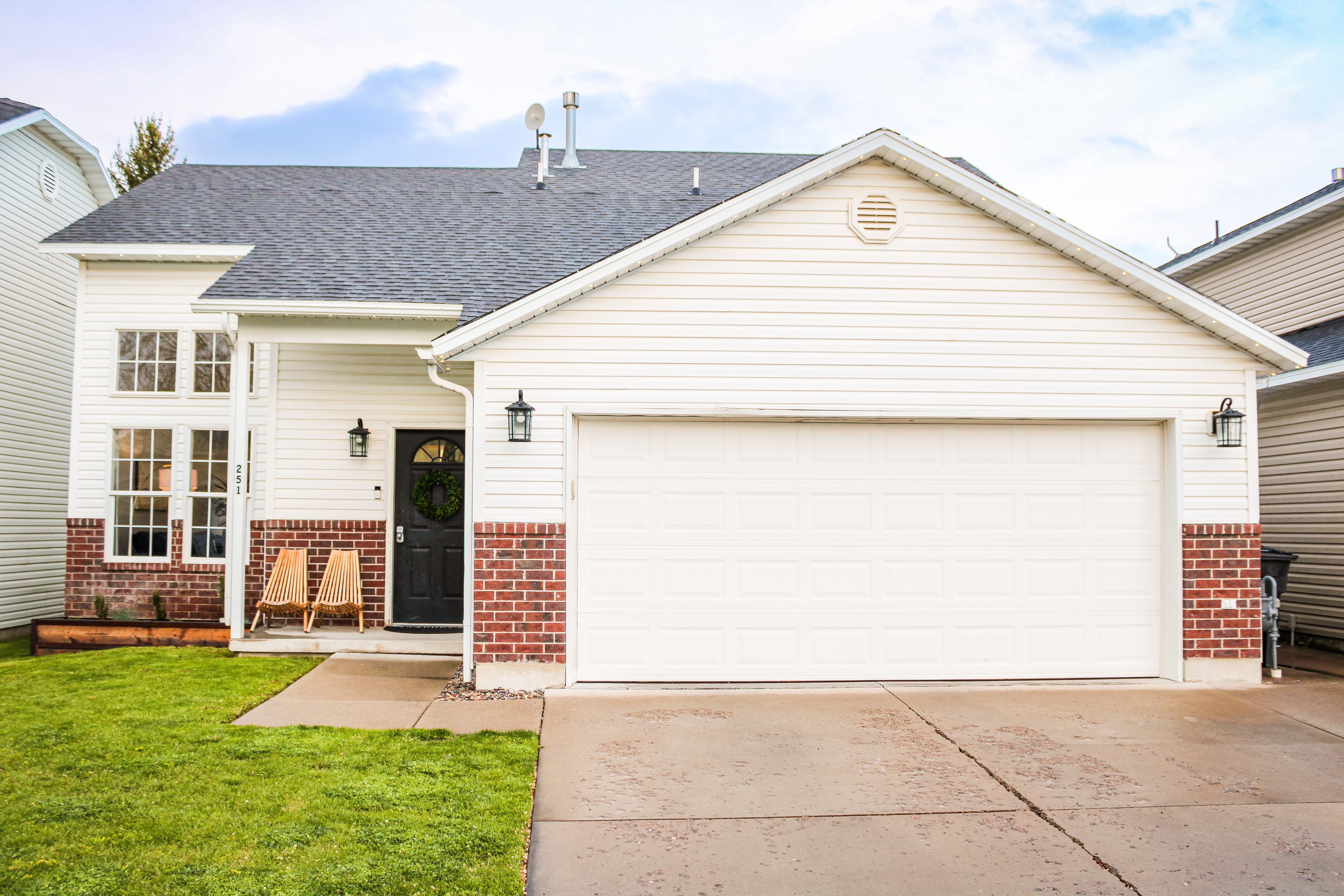 View of front of house with an attached garage, brick siding, concrete driveway, and roof with shingles