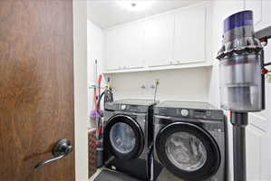 Laundry area with cabinet space and washing machine and dryer