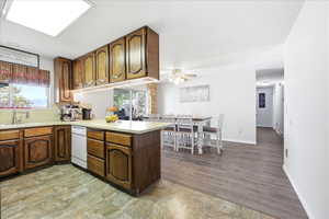 Kitchen featuring light countertops, a peninsula, a ceiling fan, and light wood-style floors