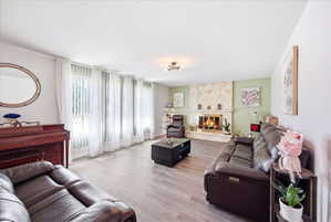 Living room with wood finished floors and a stone fireplace