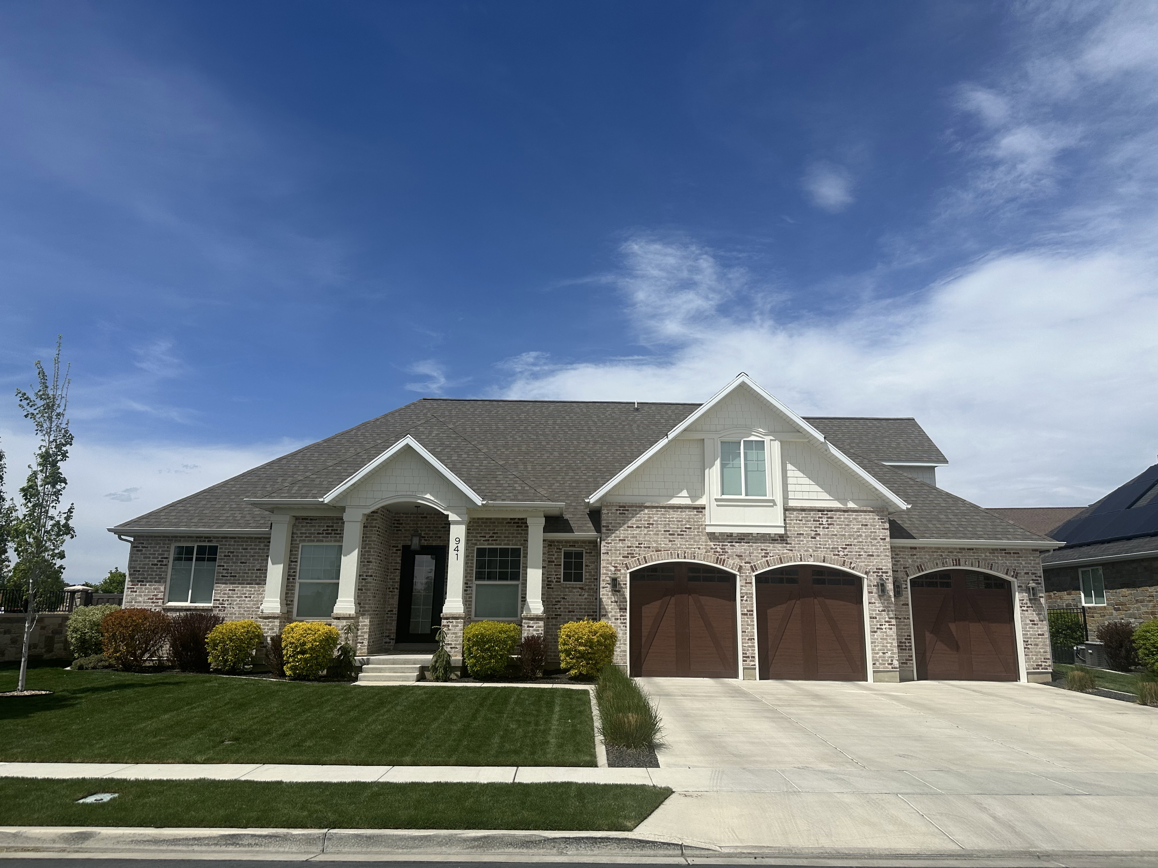 Craftsman inspired home with concrete driveway, roof with shingles, a front yard, and a porch
