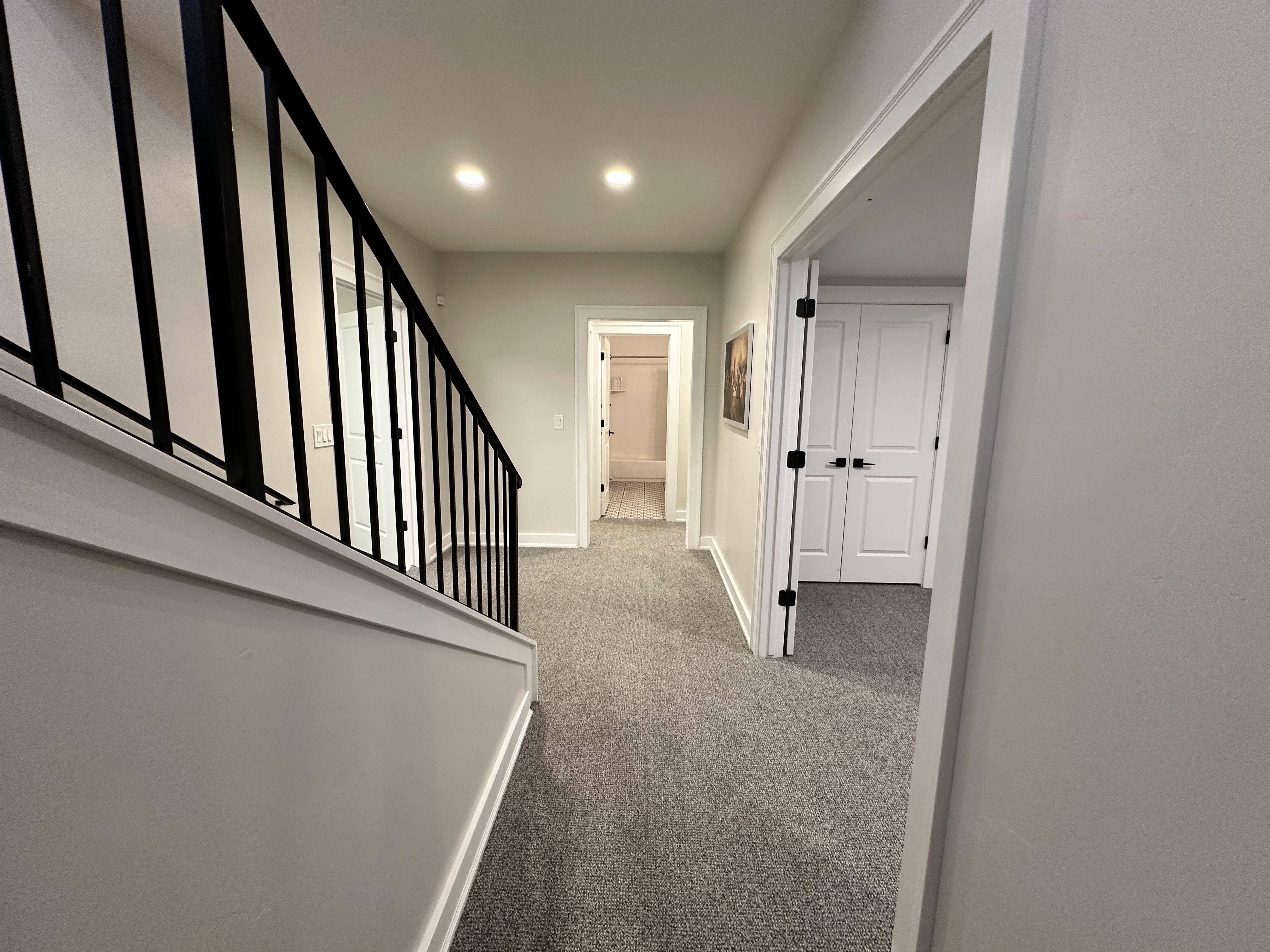 Hallway with light carpet and stairway