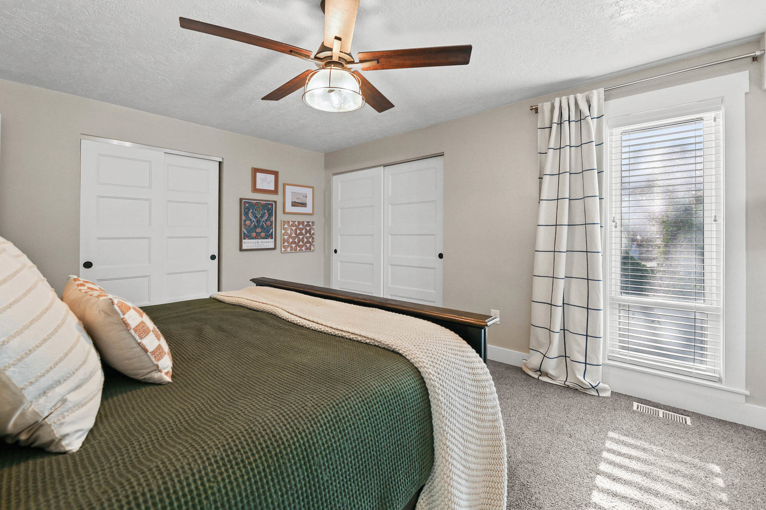 Bedroom with a closet, carpet floors, a textured ceiling, and a ceiling fan
