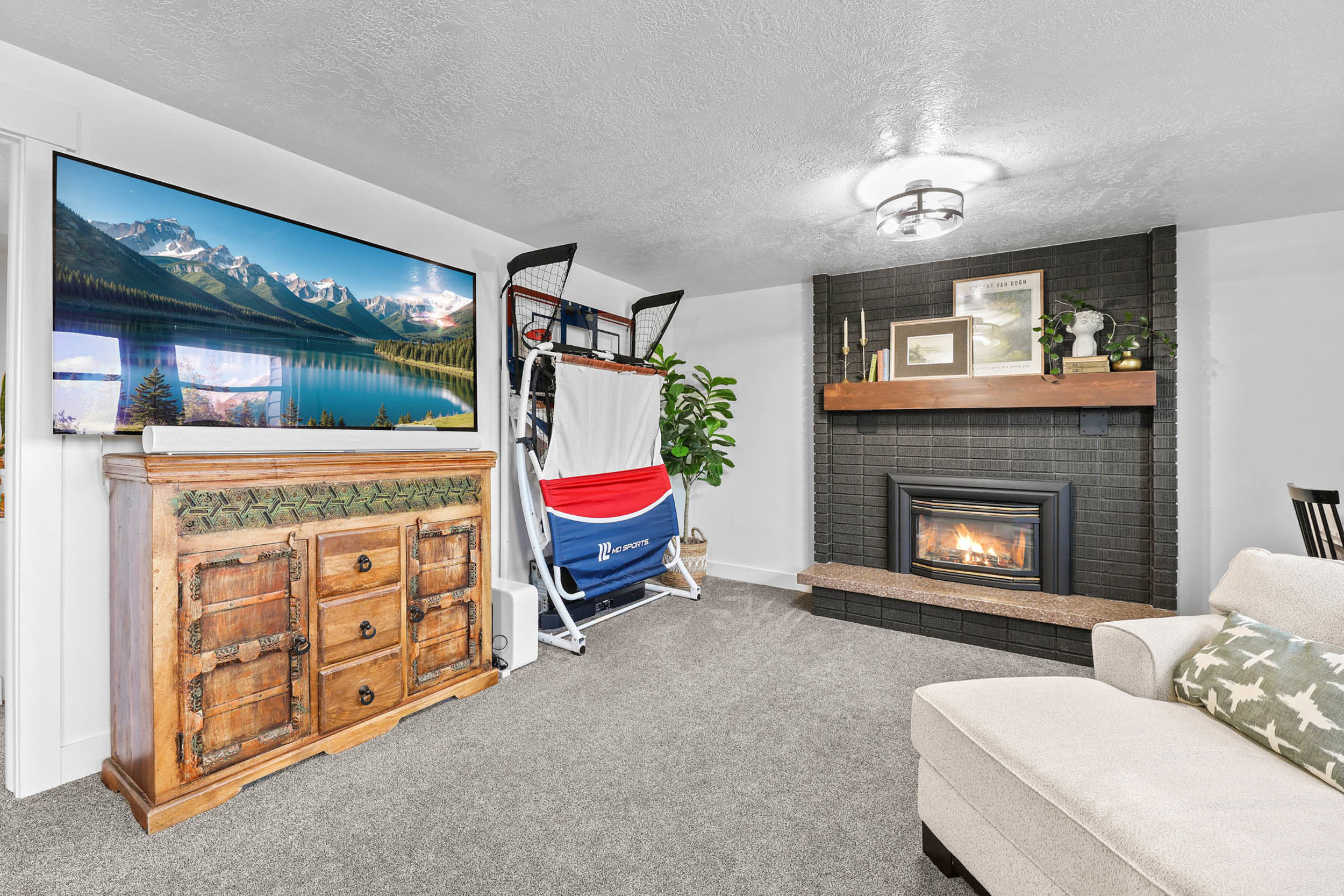 Living area with carpet, a fireplace, and a textured ceiling