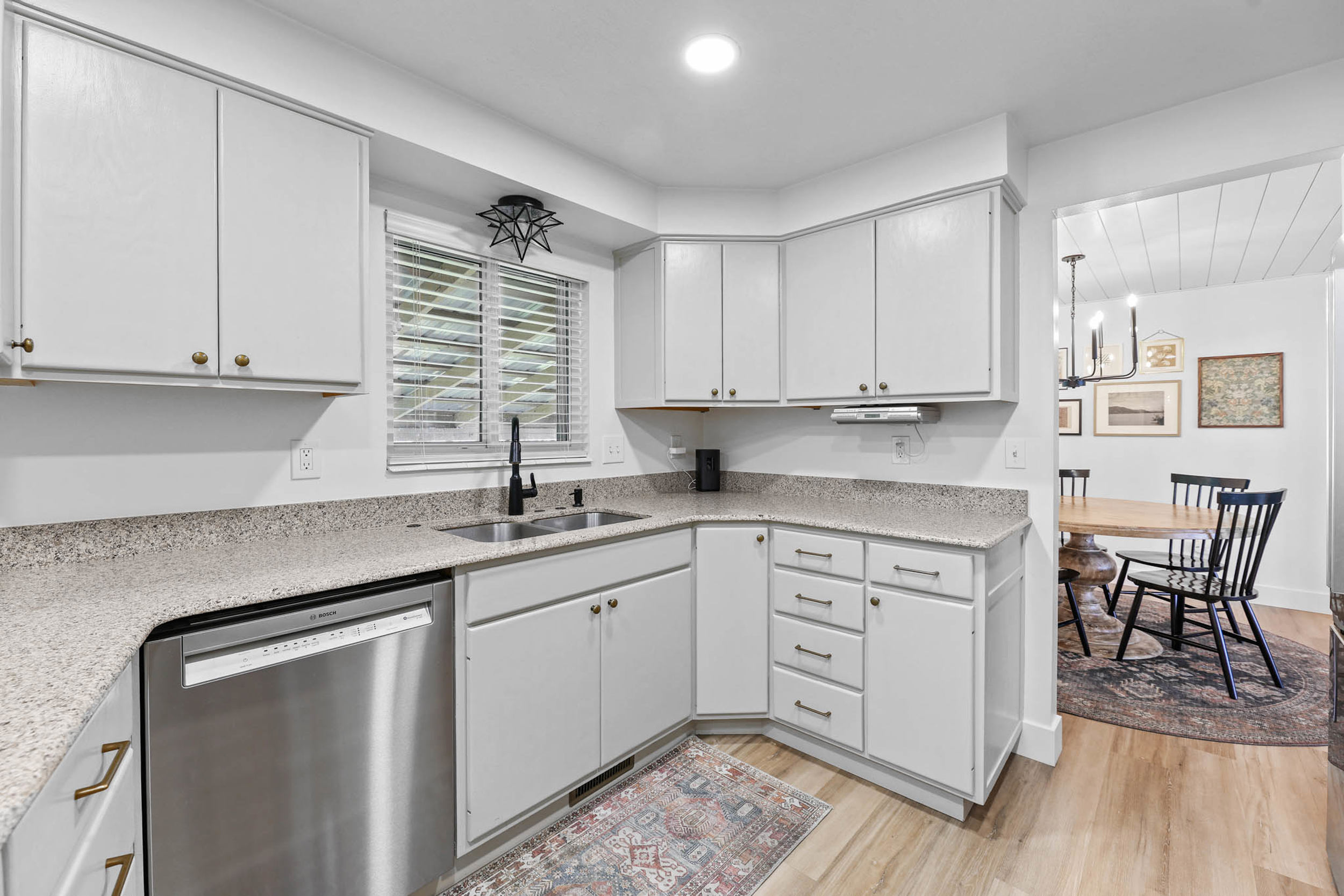 Kitchen with dishwasher, light wood-style flooring, light stone counters, recessed lighting, and white cabinetry