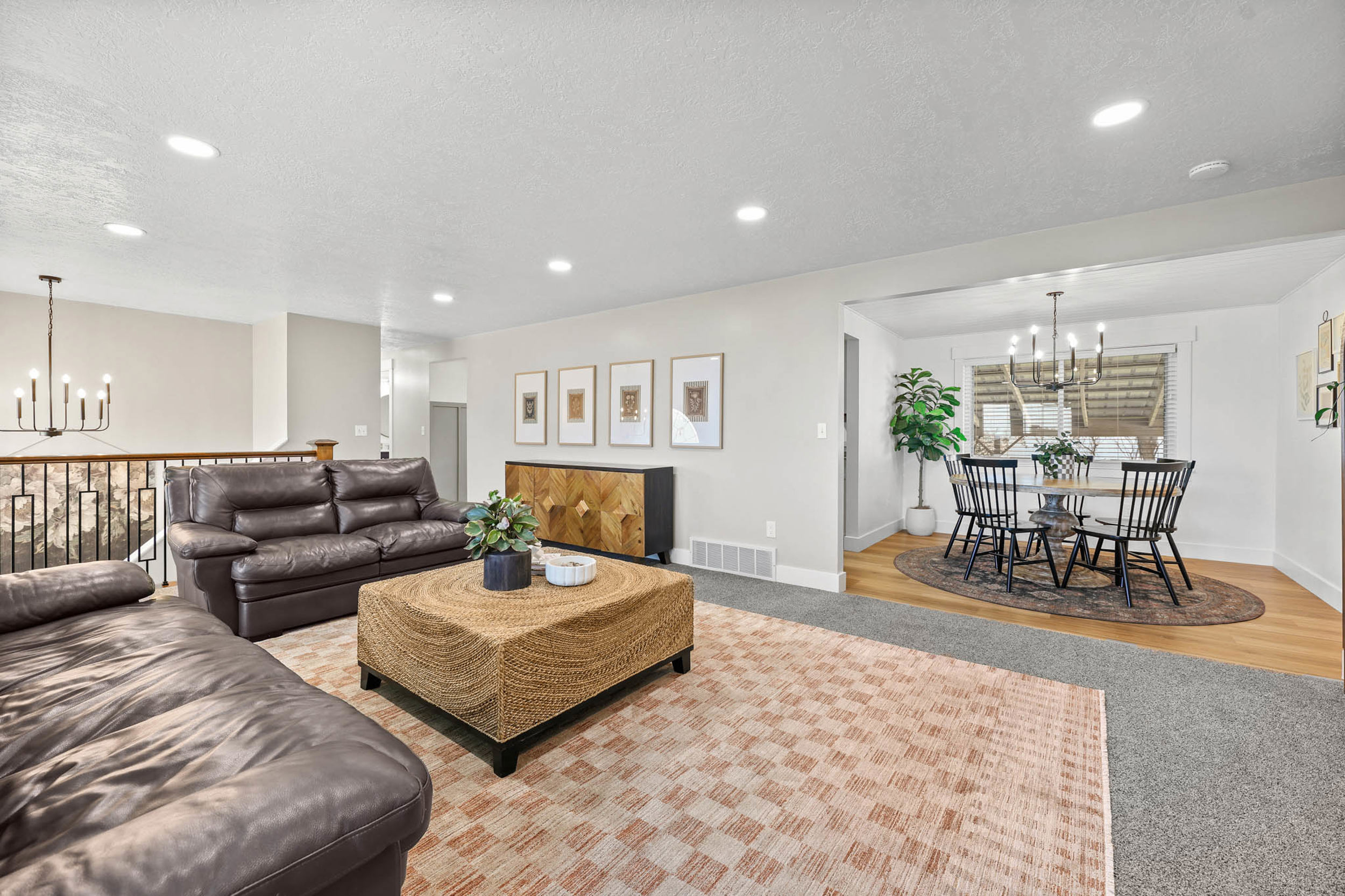 Living area with hanging lights, light colored carpet, and a textured ceiling