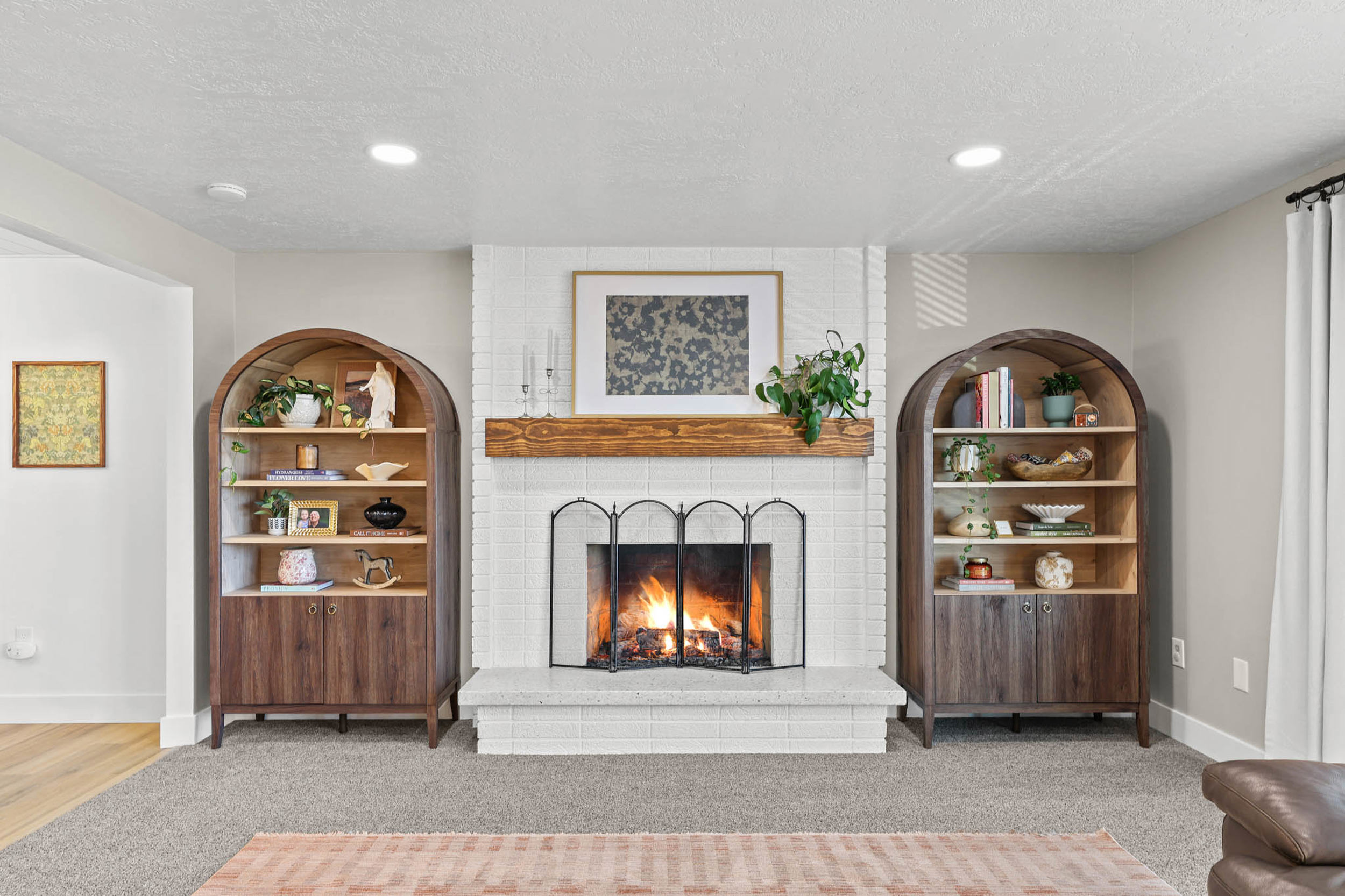 Living area featuring a brick fireplace, light carpet, a textured ceiling, and recessed lighting