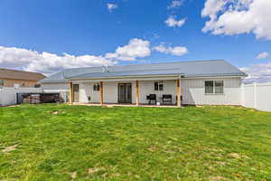 Rear view of house with a fenced backyard, a metal roof, and french doors