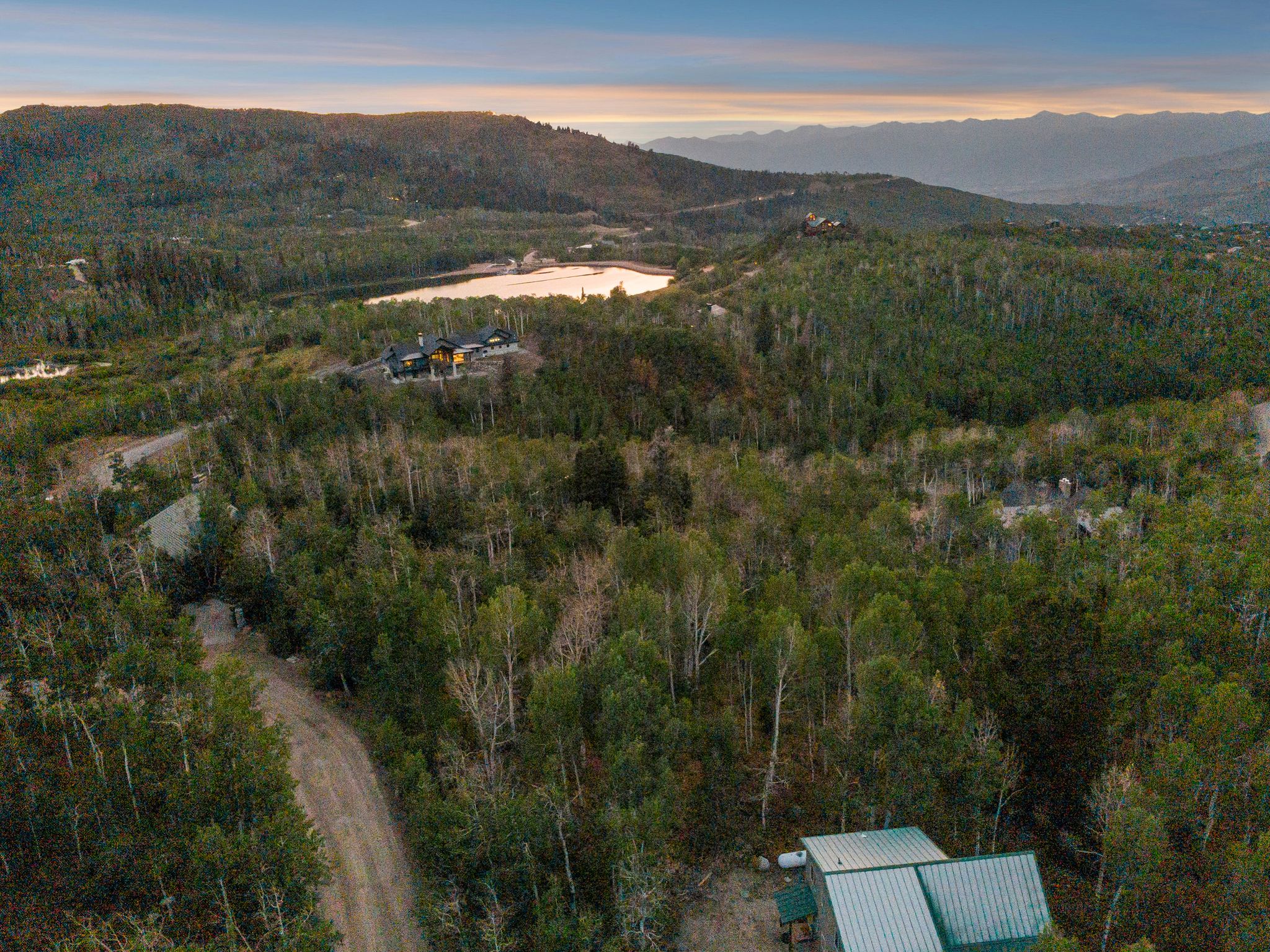 Drone / aerial view of a mountain backdrop and a heavily wooded area