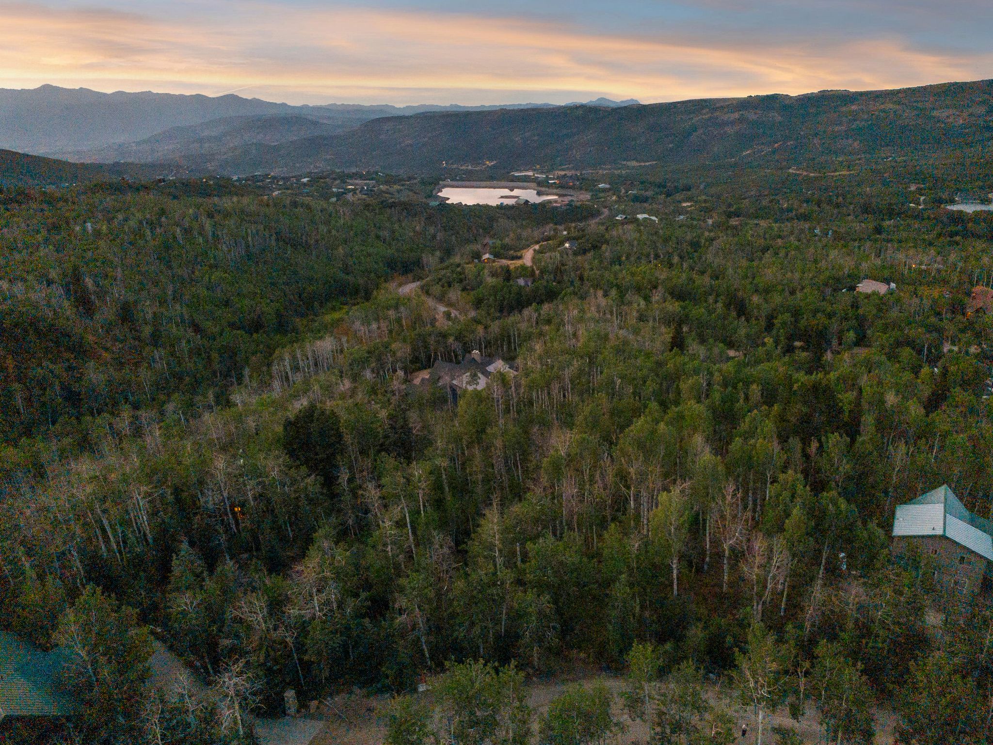 Aerial view at dusk of a water and mountain view and a forest view