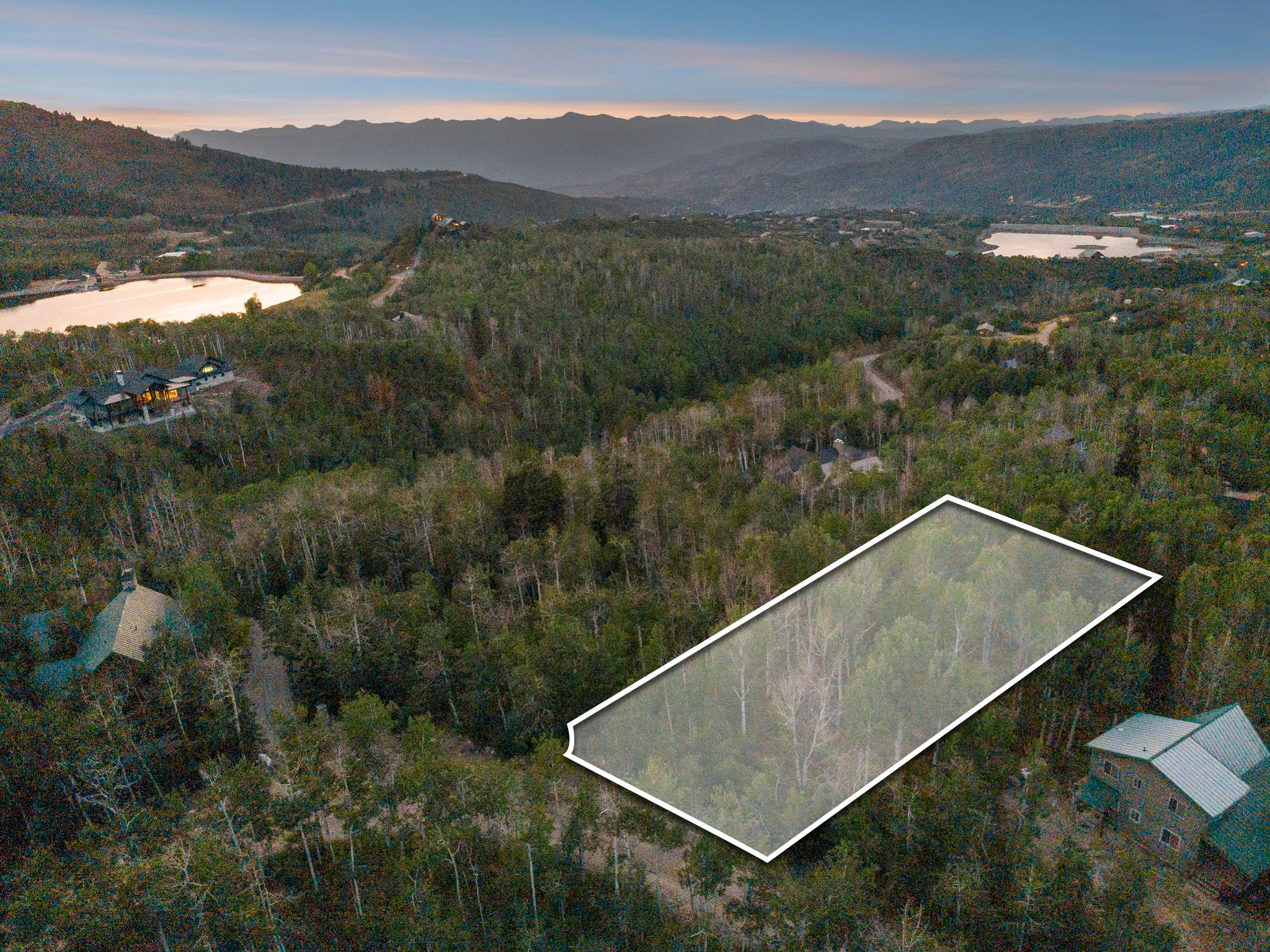 Aerial view of property and surrounding area with property parcel outlined and a water and mountain view