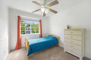 Bedroom featuring carpet, a ceiling fan, and crown molding