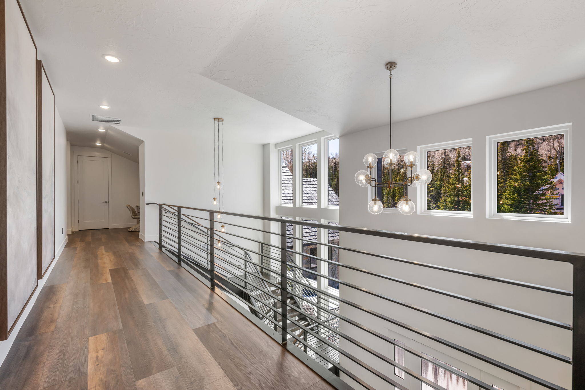 Hall featuring dark wood-style floors and a chandelier