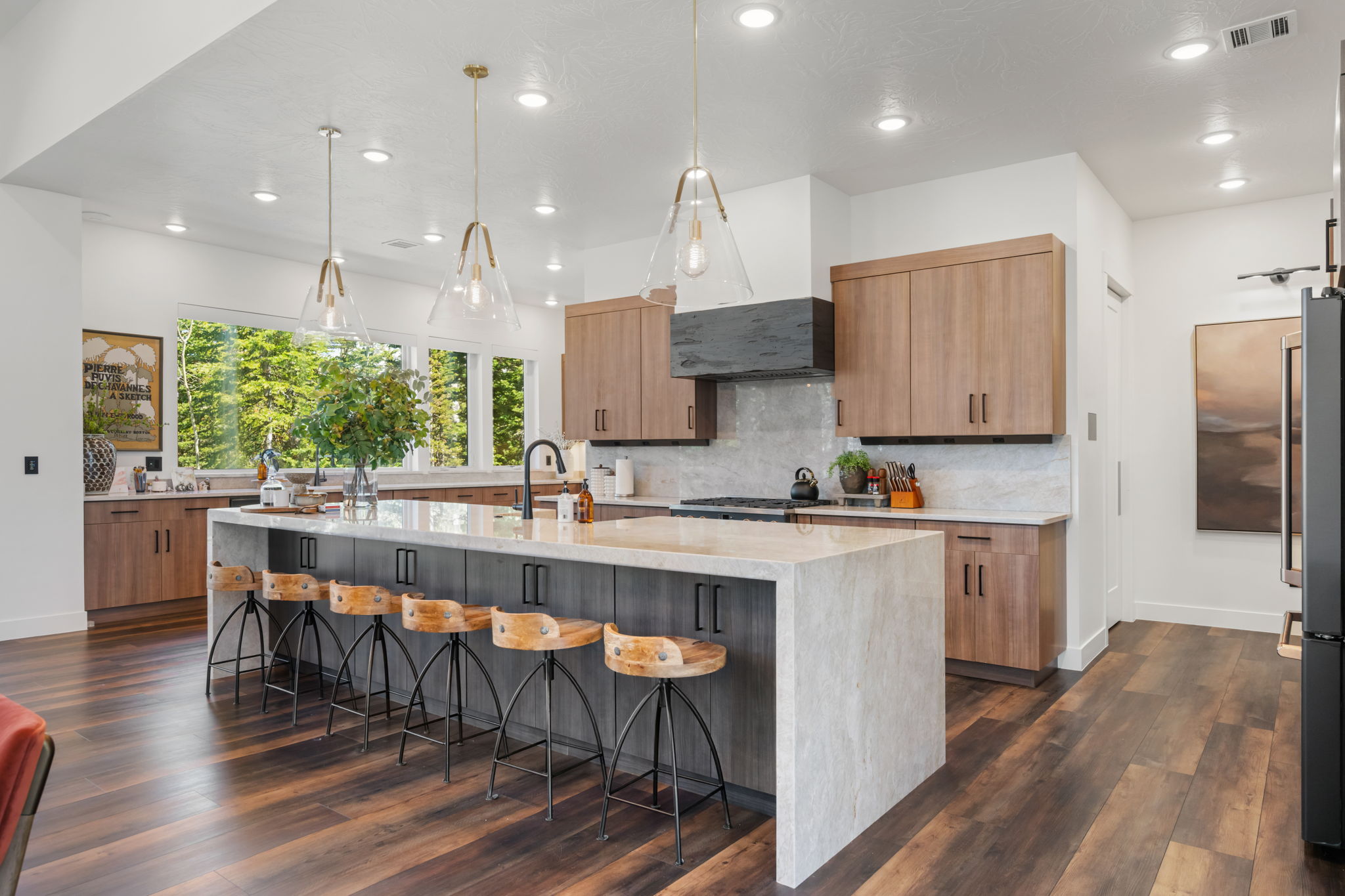 Kitchen featuring light stone countertops, dark wood-type flooring, pendant lighting, and freestanding refrigerator