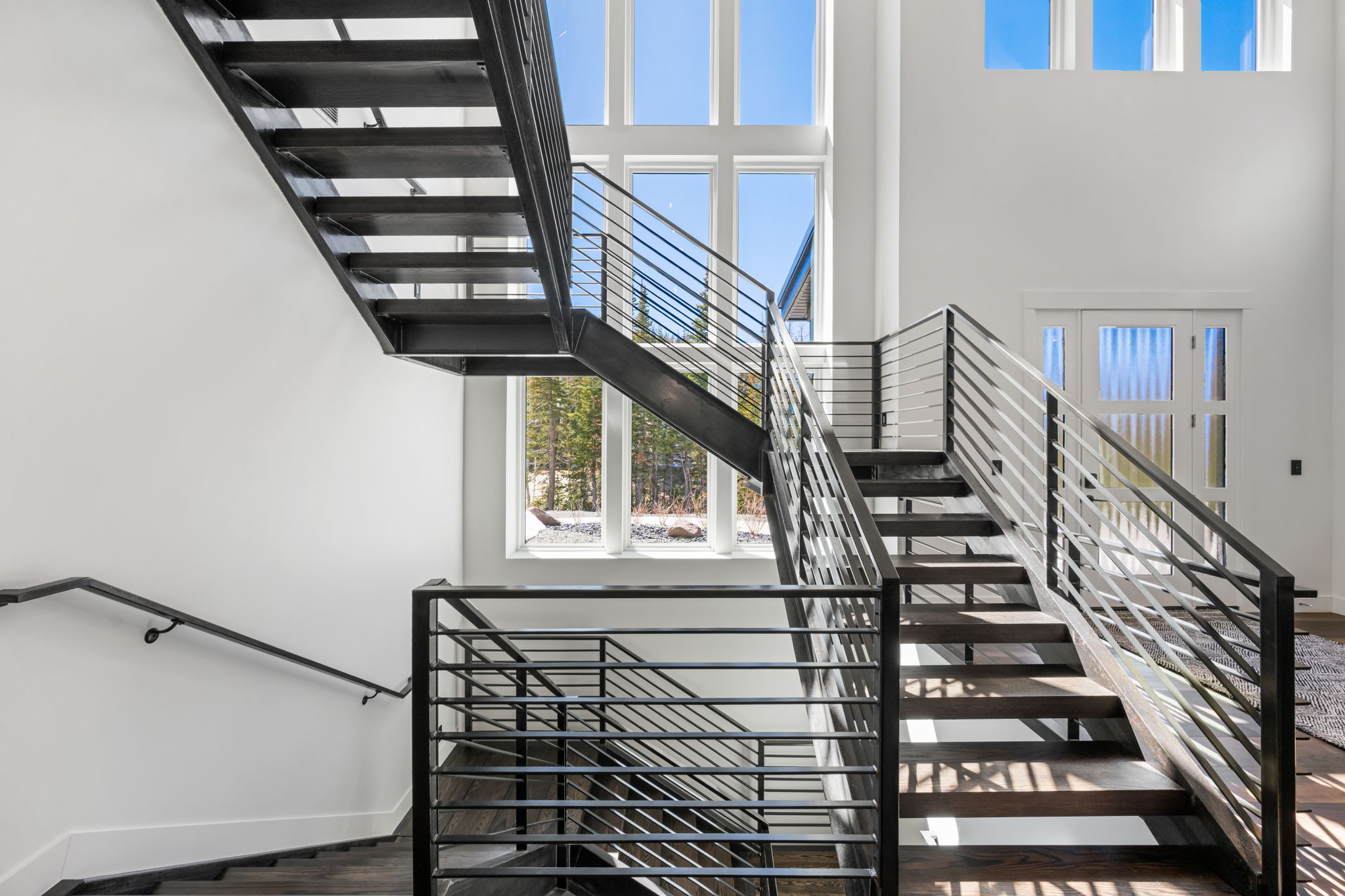 Stairway with a high ceiling and wood finished floors