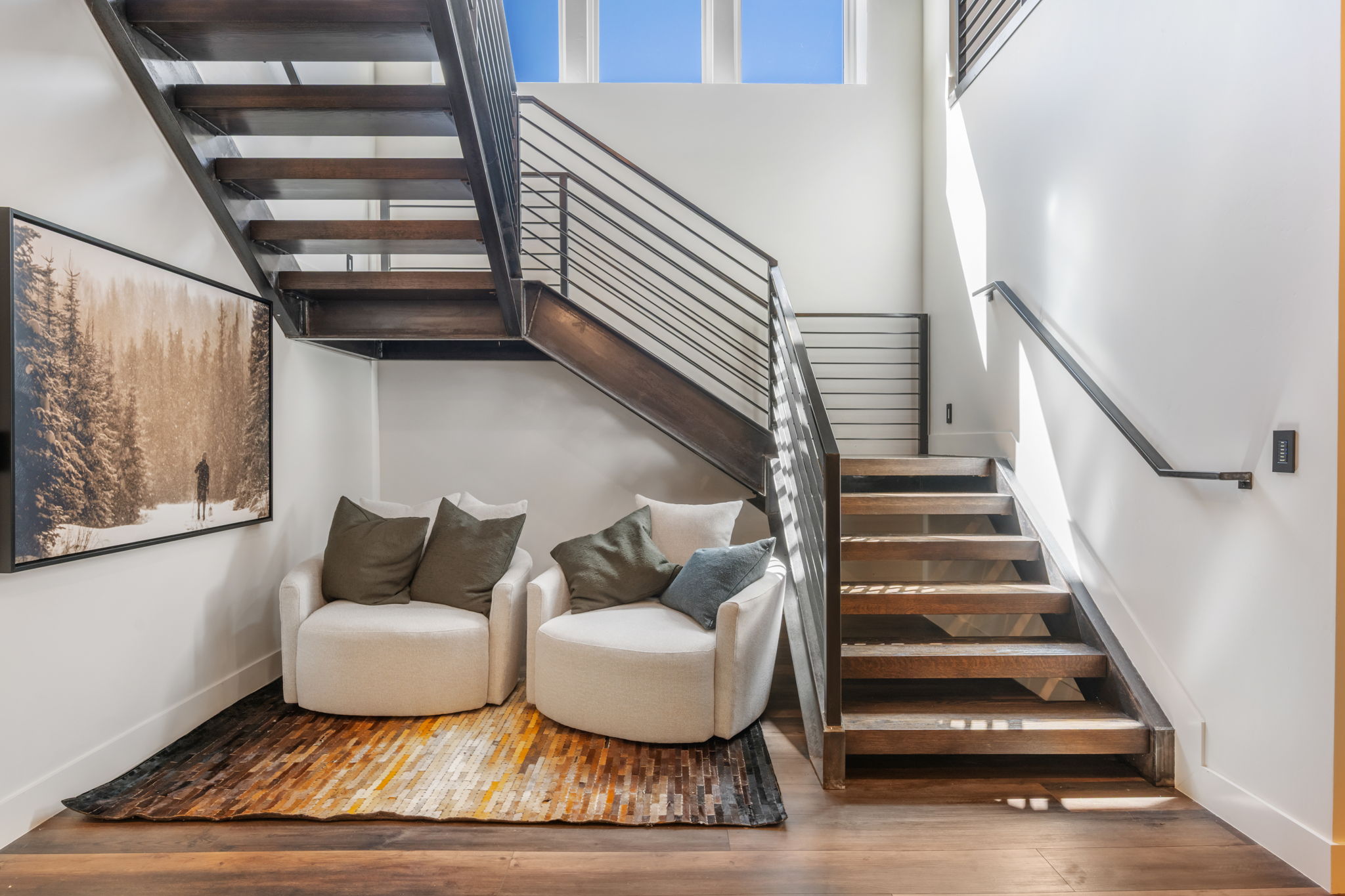 Stairs featuring wood finished floors and a high ceiling