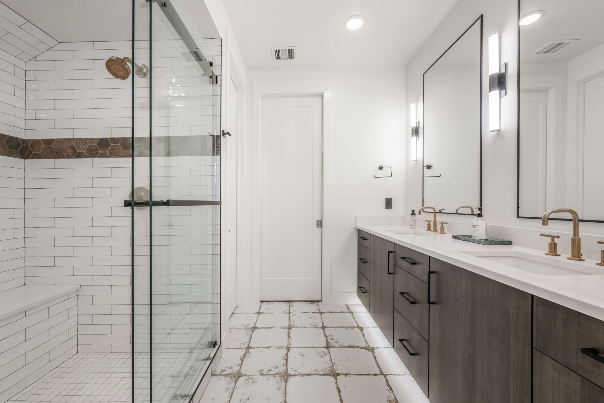 Bathroom with double vanity, a shower stall, and recessed lighting