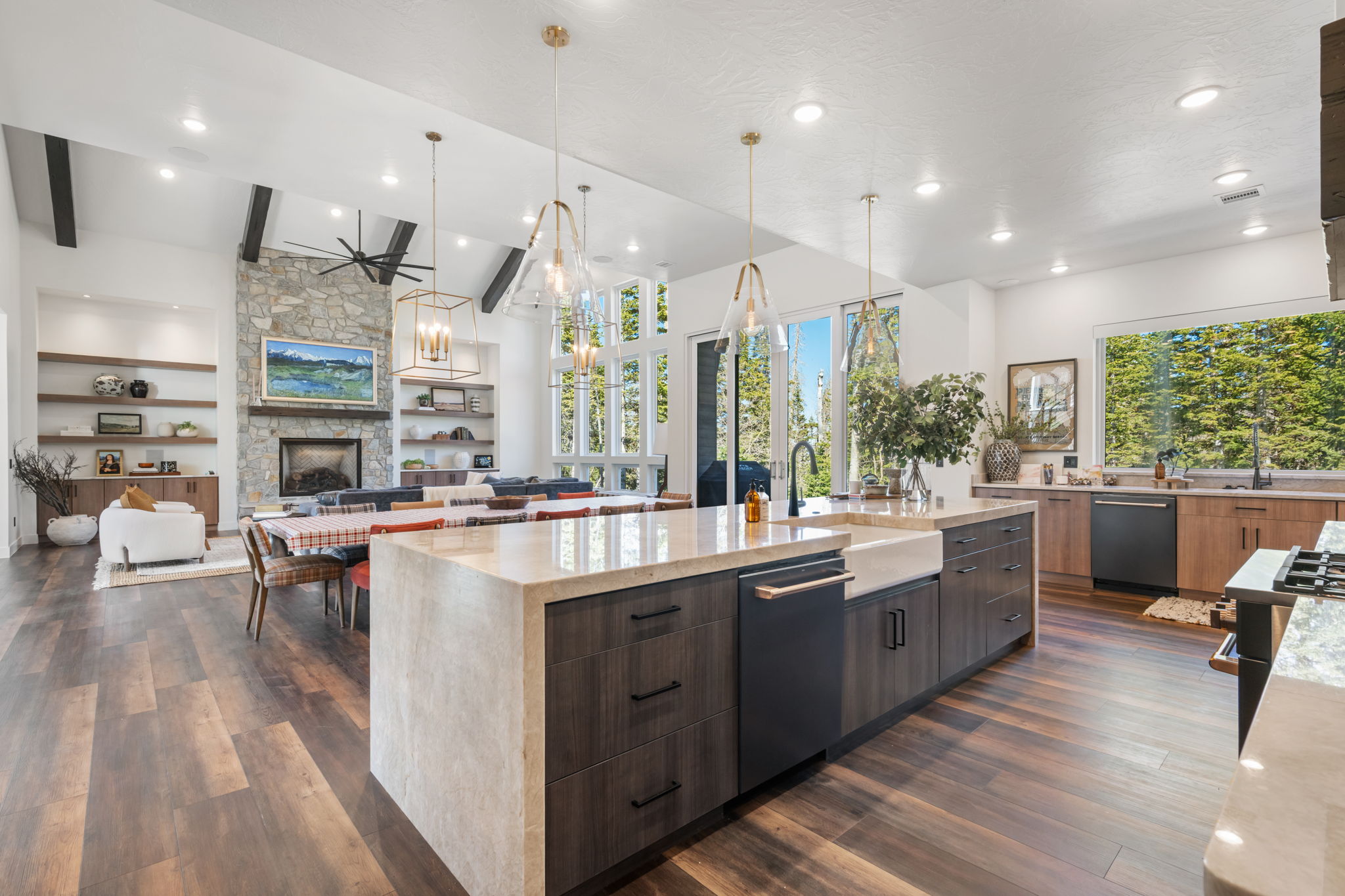 Kitchen featuring light stone counters, a large island, open floor plan, modern cabinets, and two tone cabinets