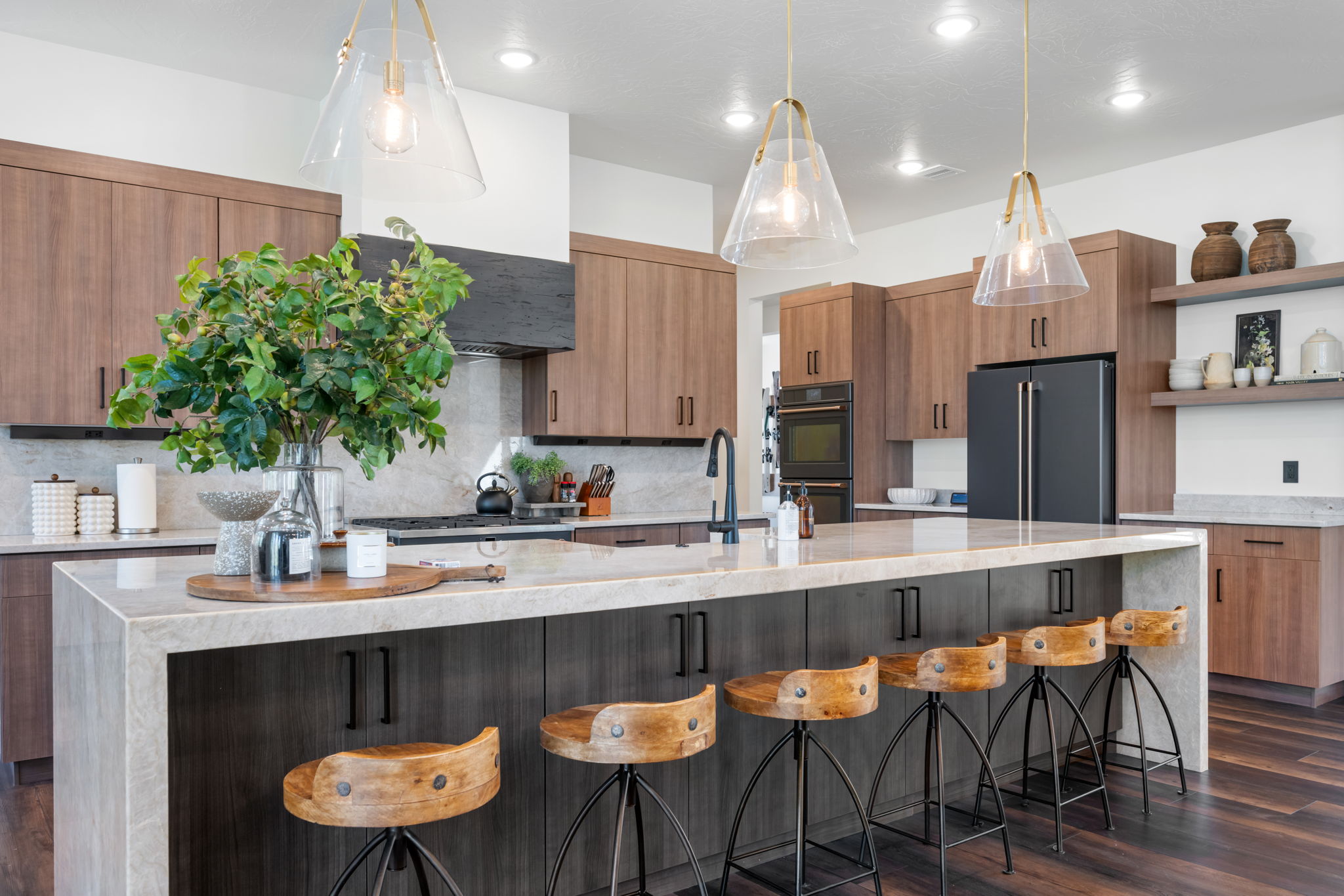 Kitchen with light stone counters, a breakfast bar area, modern cabinets, and pendant lighting
