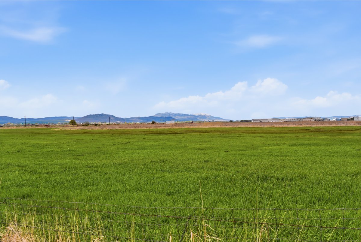 View of mountain backdrop with rural landscape and agricultural land