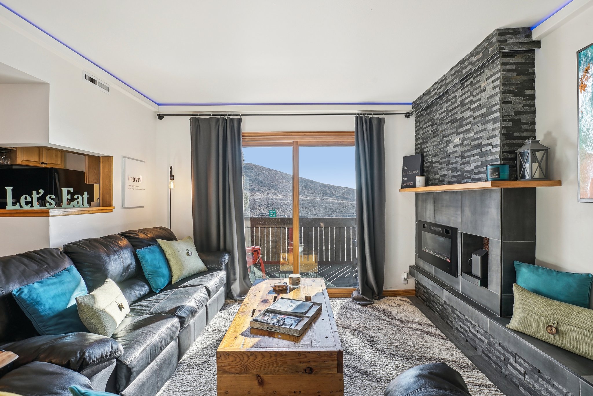 Living area with a mountain view, a large fireplace, and wood finished floors