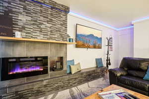 Living room with wood finished floors and a glass covered fireplace