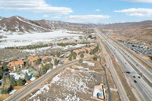 Snowy aerial view featuring a mountain view and a residential view