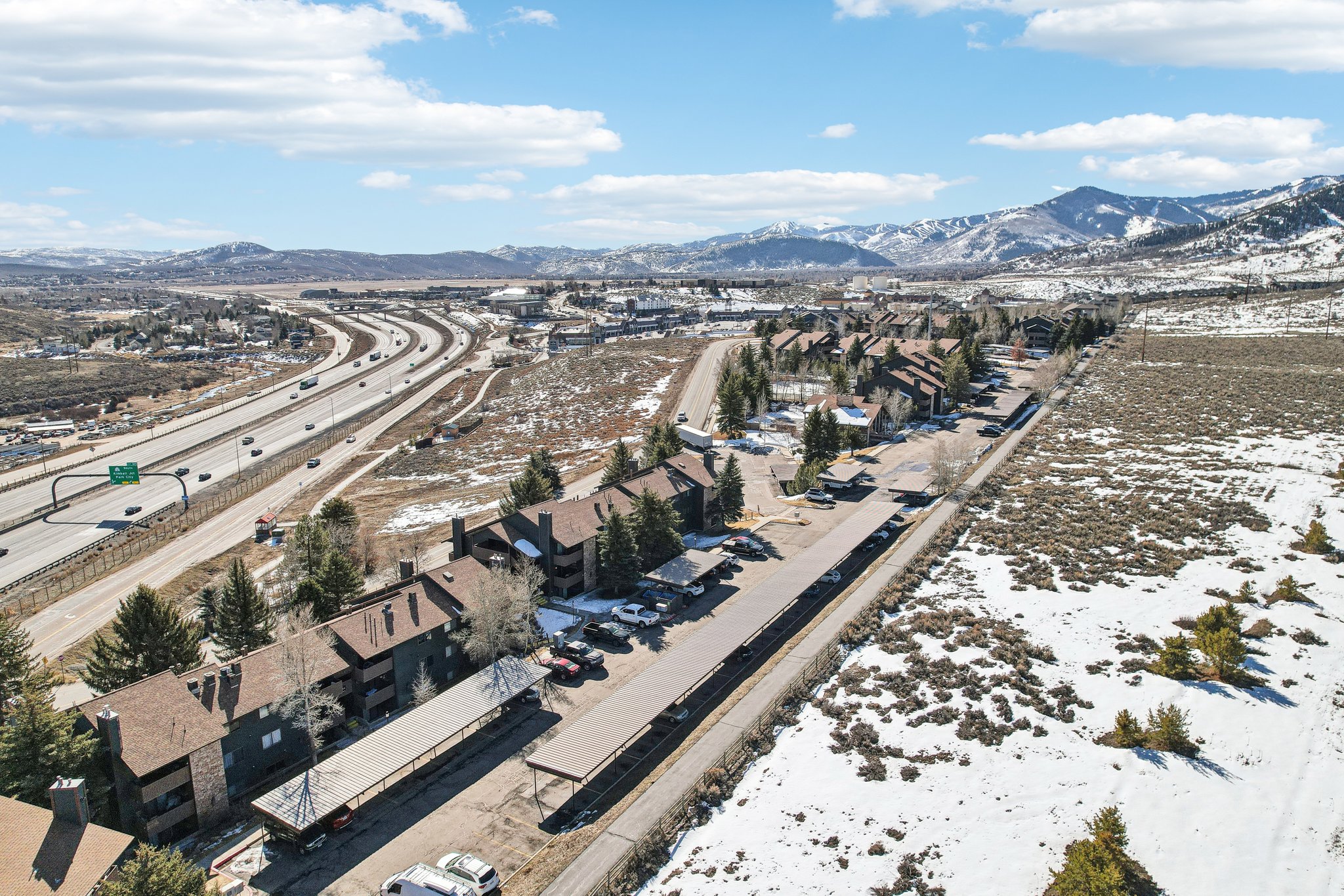 Aerial perspective of suburban area featuring mountains and a main thoroughfare