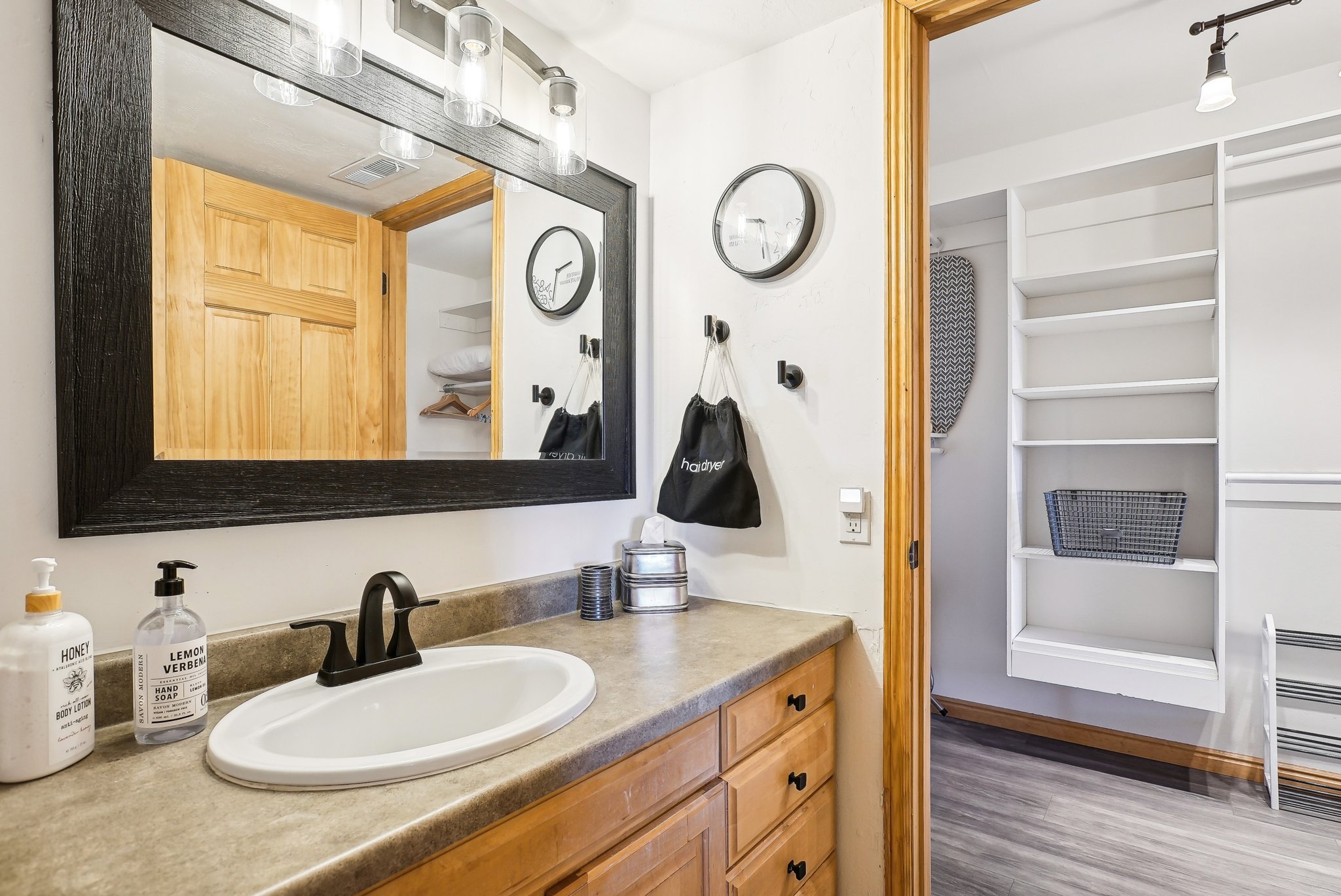 Bathroom with vanity, wood finished floors, and a closet