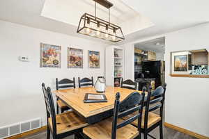 Dining space with baseboards and dark wood-style flooring