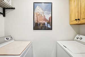 Laundry area featuring washing machine and dryer and cabinet space