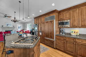Kitchen featuring Alder cabinets, open floor plan, a center island, and a kitchen breakfast bar