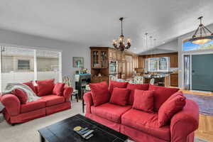 Open concept living area featuring a chandelier and vaulted ceiling