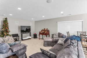 Basement living room with light carpet, a textured ceiling, recessed lighting and included surround sound system