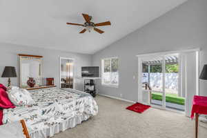 Primary bedroom featuring access to backyard patio, lofted ceiling, light carpet, connected bathroom, and a ceiling fan