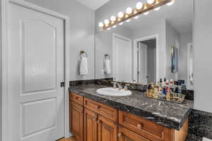 Primary bathroom with marble vanity and ample lighting