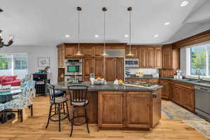 Kitchen featuring plenty of natural light, Alder cabinetry, light hardwood floors, and slab granite countertops