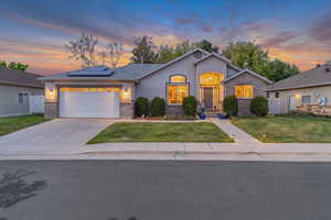 Ranch-style home with solar panels, a 3 garage, stucco siding, and spacious backyard