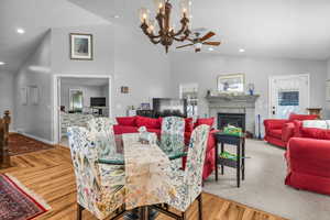 Dining room featuring lofted ceiling, light hardwood floors and a chandelier