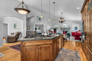 Kitchen with open floor plan, decorative light fixtures, and vaulted ceiling