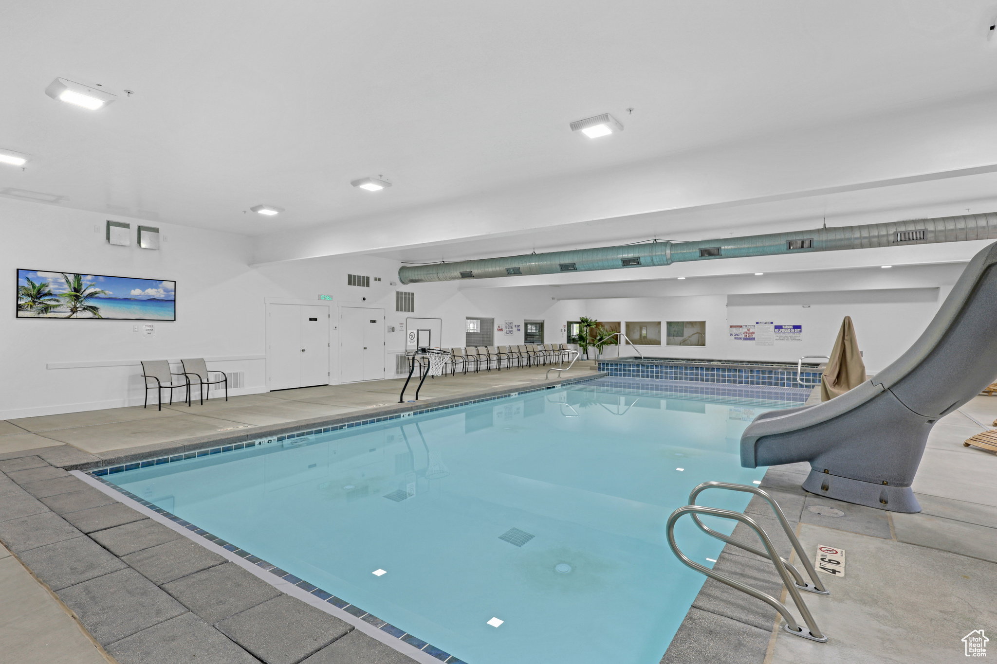Indoor community pool featuring a water slide