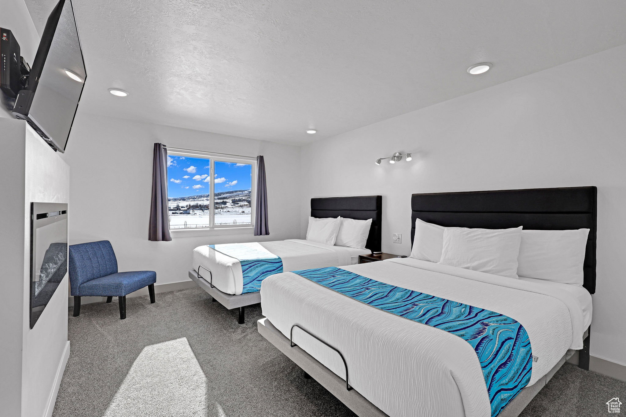 Carpeted bedroom with a fireplace and baseboards