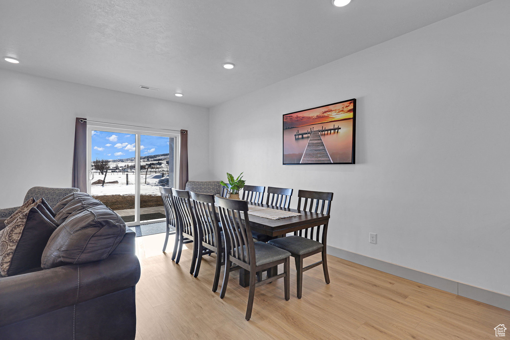 Dining room with light wood-style floors and recessed lighting