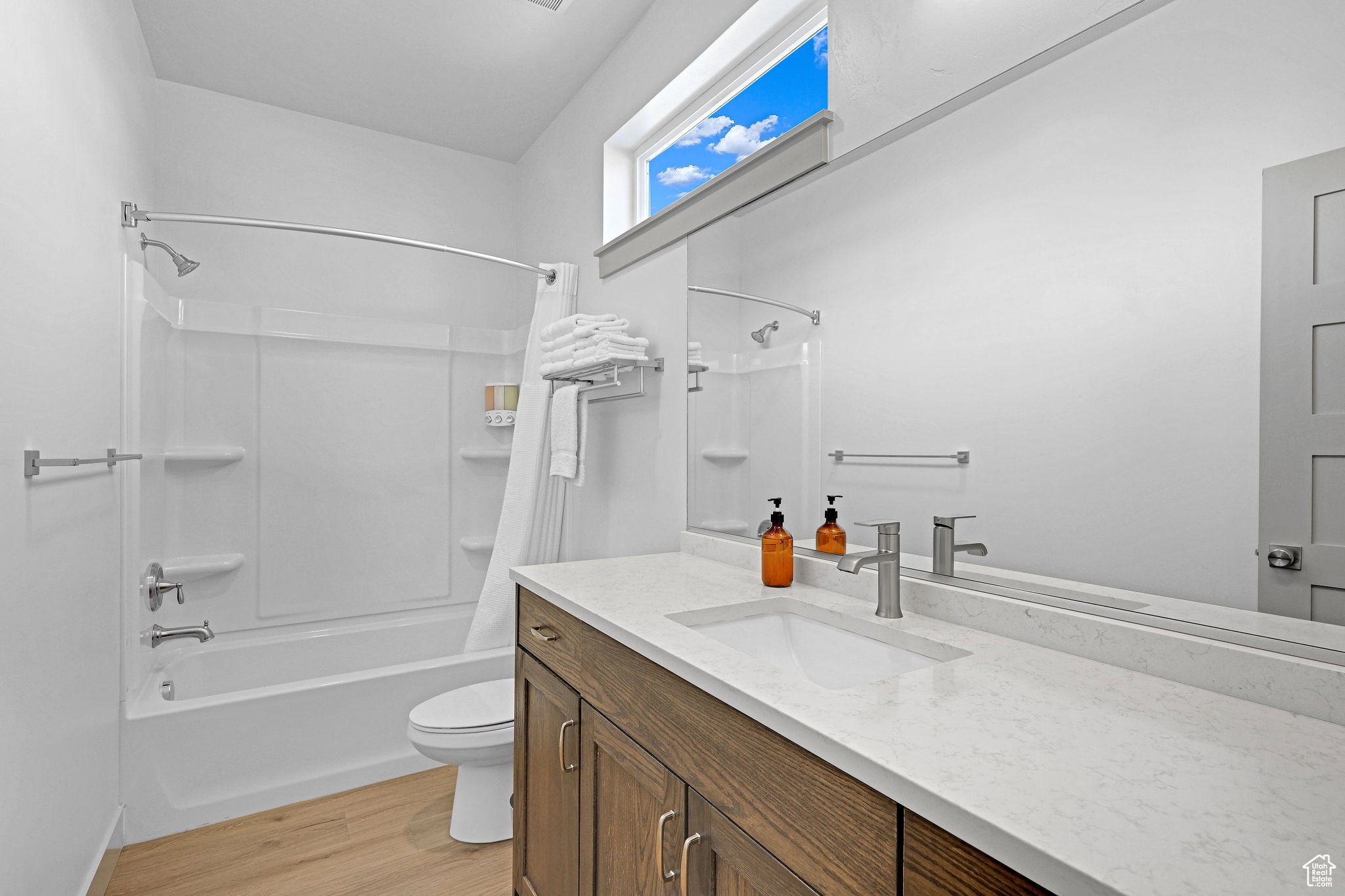 Bathroom with vanity, light wood-style floors, and shower / tub combo