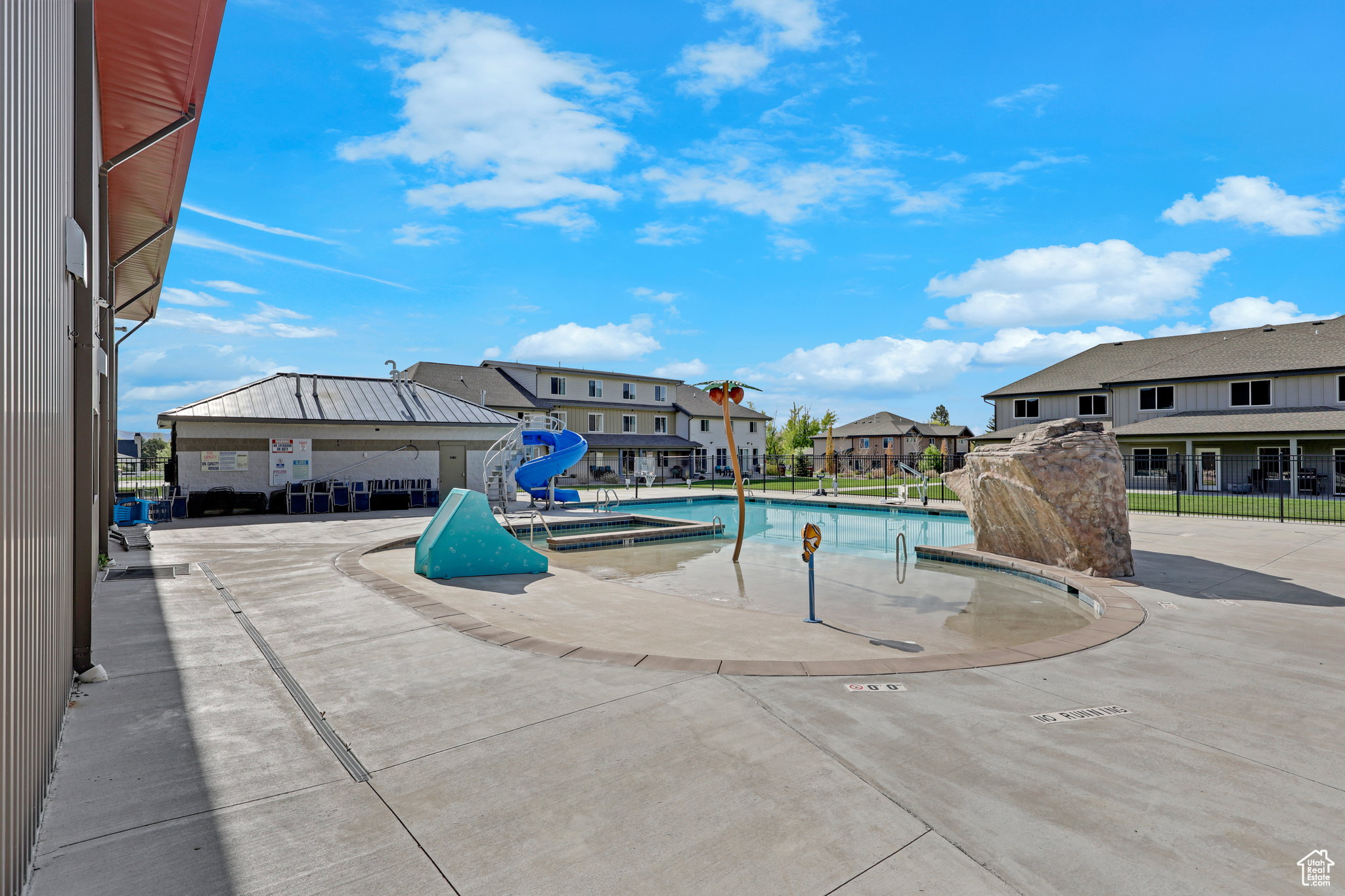 Community pool featuring a patio area, a residential view, and a water slide