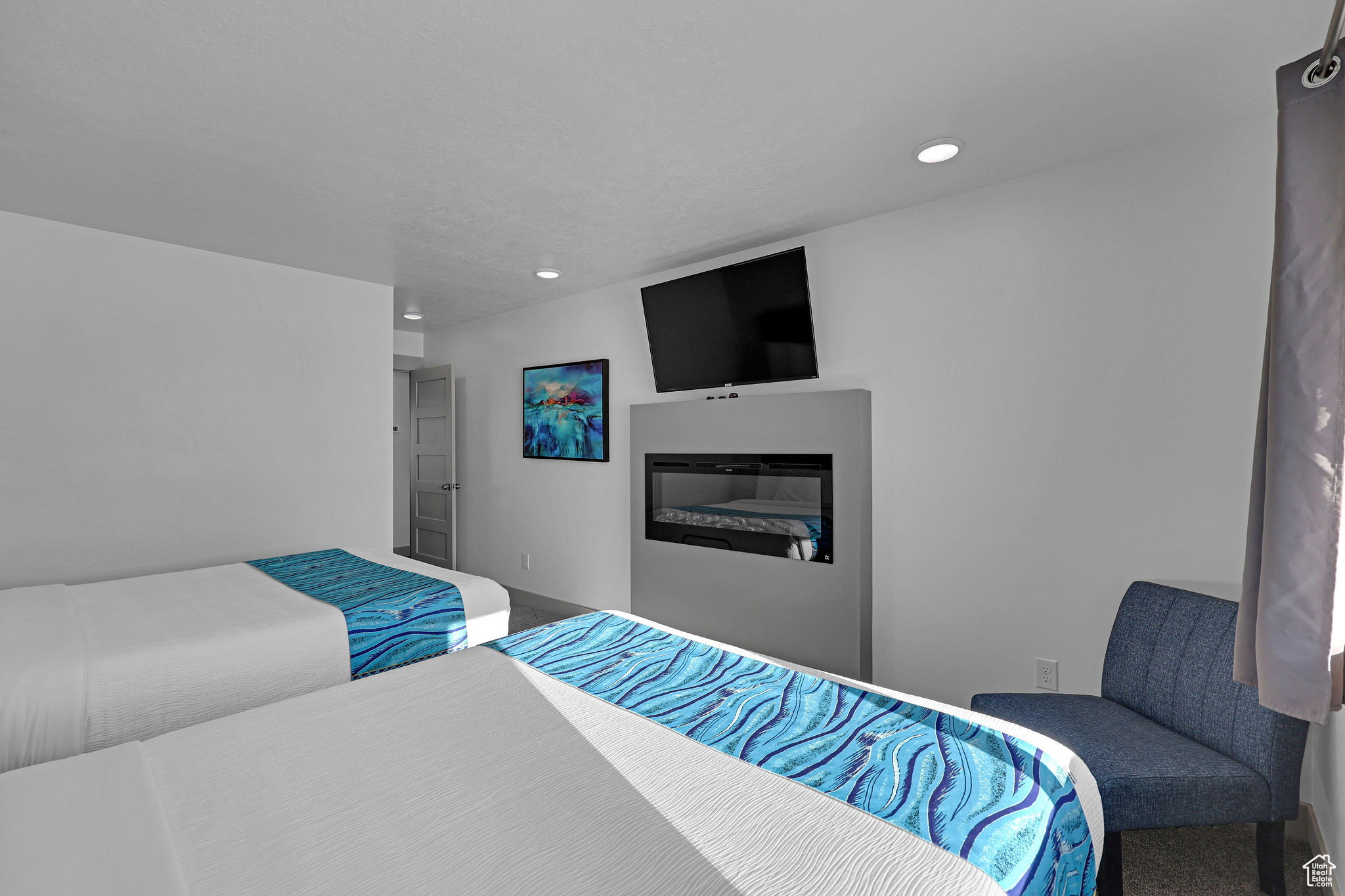 Bedroom with a glass covered fireplace and recessed lighting