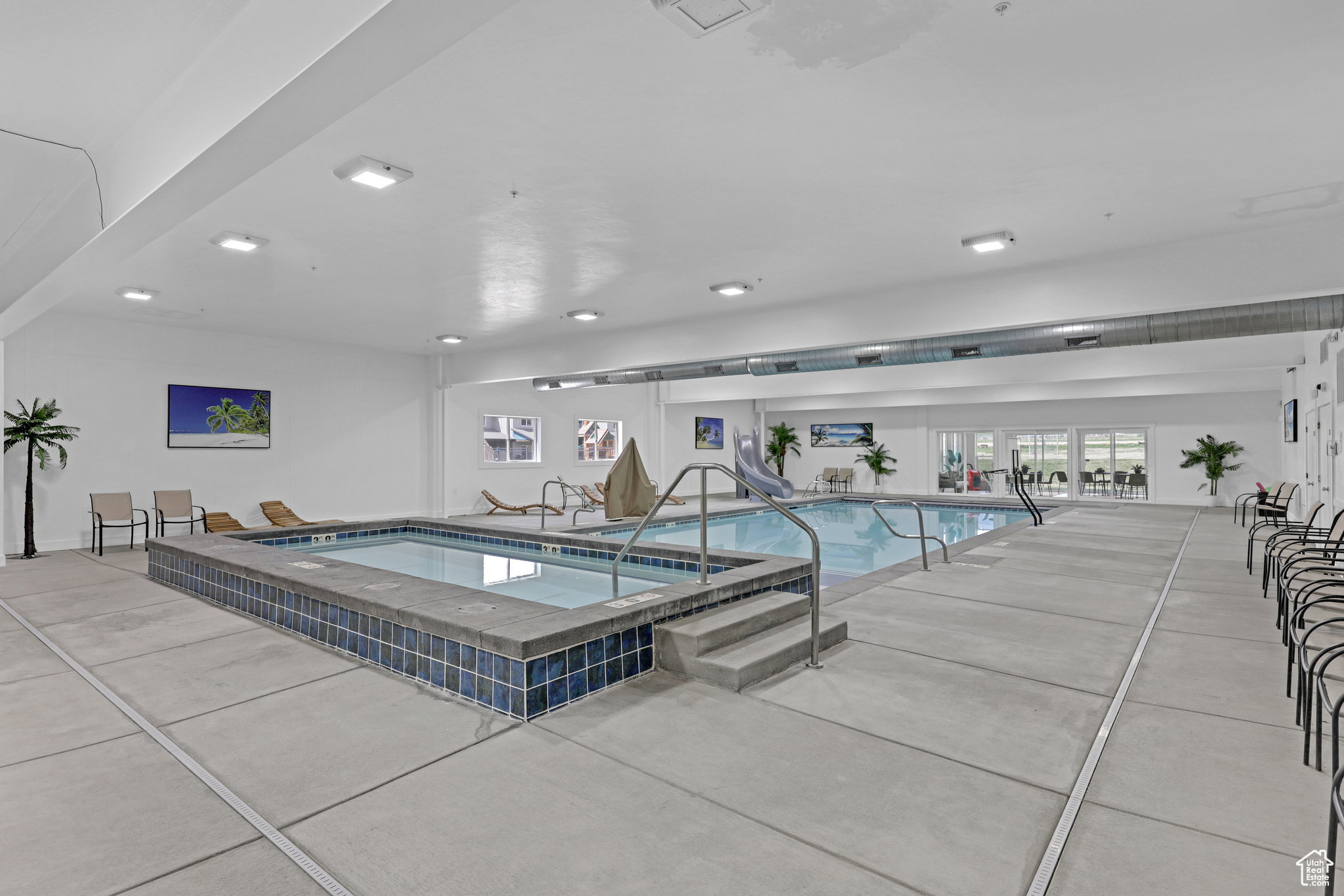 Indoor pool featuring a hot tub
