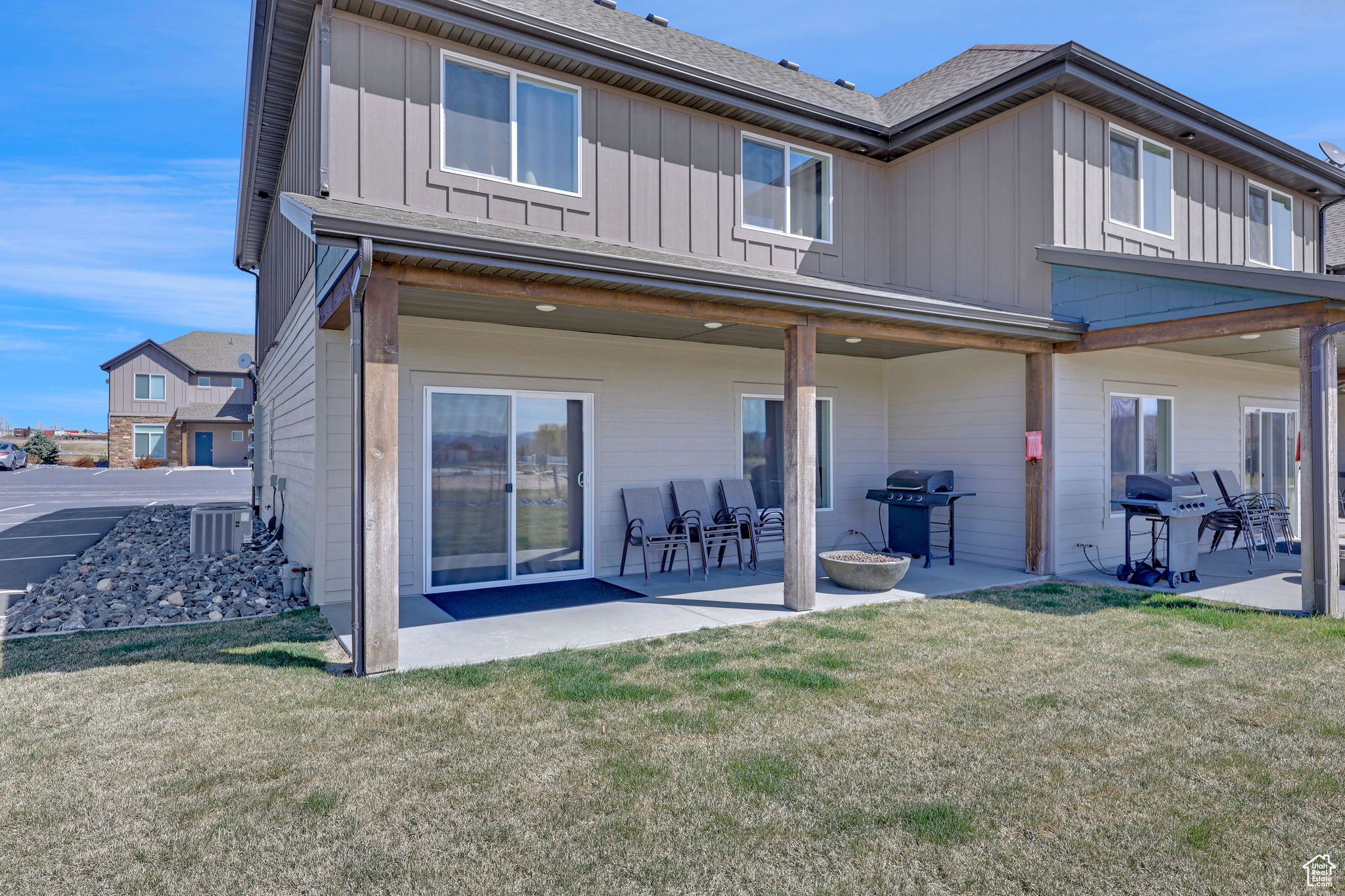 Rear view of house featuring board and batten siding, a yard, and a patio area