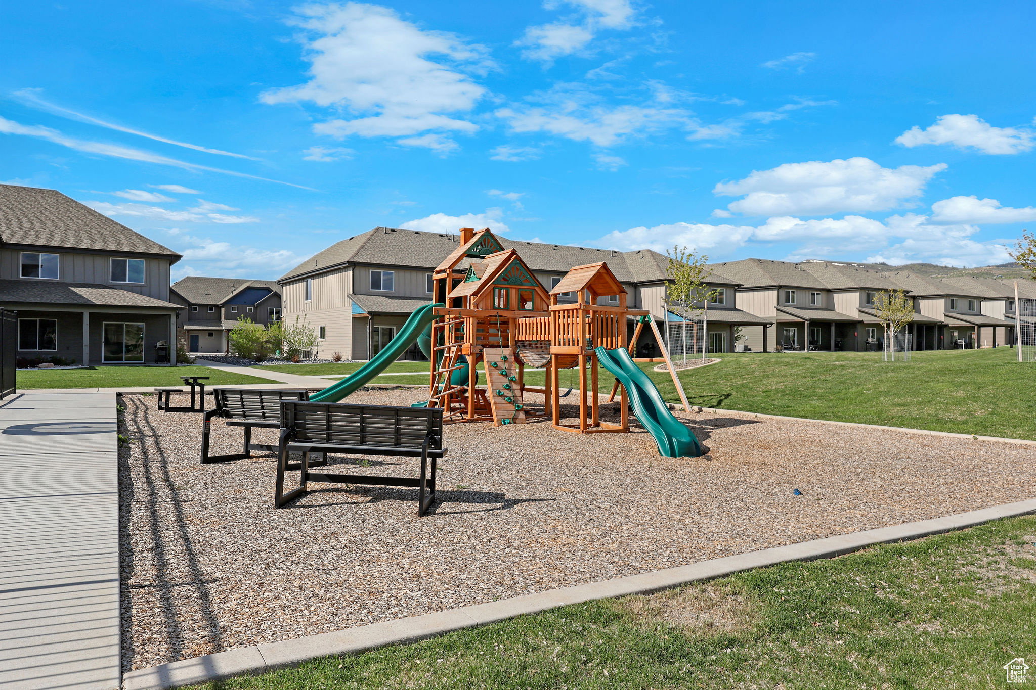 Community play area with a residential view and a lawn